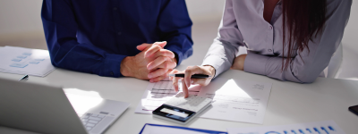 Two people with a calculator and paperwork