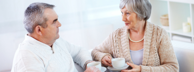 A man and a lady sitting talking with a cup of tea