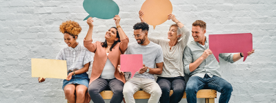 People sitting on a bench holding blank speech bubbles